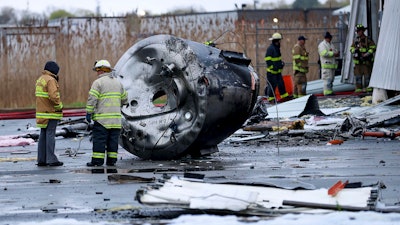 Investigators from the State Fire Marshal's Office examine a vat that was hurled out of the pharmaceutical plant and landed an estimated 30 feet away in Newburyport, Mass., Thursday, May 4, 2023.