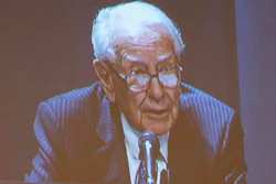 Shareholders watch Warren Buffett from the overflow room during the Berkshire Hathaway annual meeting on Saturday, May 6, 2023, in Omaha, Neb.