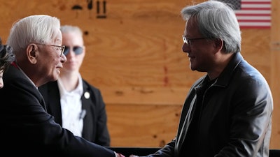 Taiwan Semiconductor Manufacturing Company founder Morris Chang, left, shakes hands with Nvidia Co-founder, President, and CEO Jensen Huang, right, at the TSMC facility under construction in Phoenix, Tuesday, Dec. 6, 2022.