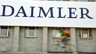 A cyclist passes a logo of German car company Daimler in Berlin on April 8, 2009. German truck maker Daimler, Japan’s top automaker Toyota and two other automakers said Tuesday, May 30, 2023, they will work together on new technologies, including use of hydrogen fuel, to help fight climate change.