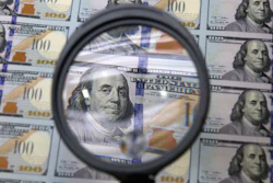 A sheet of uncut $100 bills is inspected during the printing process at the Bureau of Engraving and Printing Western Currency Facility in Fort Worth, Texas, on Sept. 24, 2013.