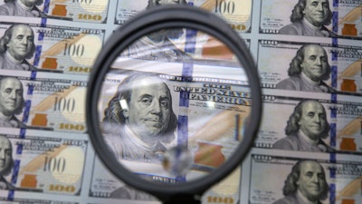 A sheet of uncut $100 bills is inspected during the printing process at the Bureau of Engraving and Printing Western Currency Facility in Fort Worth, Texas, on Sept. 24, 2013.