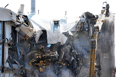 Debris falls as workers begin demolition at the site of a building collapse, Monday, June 12, 2023, in Davenport, Iowa. The six-story, 80-unit building partially collapsed May 28.