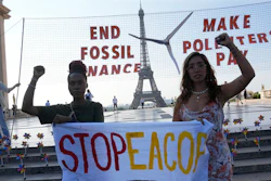 Climate activists Patience Nabukalu, of Uganda, left, and Mitzi Jonelle Tan, of the Philippines, participate in a demonstration ahead of the Global Climate Finance Summit, Wednesday, June 21, 2023 in Paris. The aim of a two-day climate and finance summit in Paris that ends Friday, June 23, was to set up concrete measures to help poor and developing countries better tackle issues like poverty and climate change.