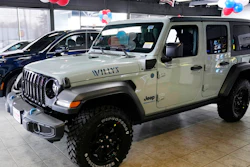 A plug-in hybrid gas/electric Jeep Wrangler is displayed on the showroom floor at the Dan O'Brien Auto Group dealership, Monday, Feb. 27, 2023, in Methuen, Mass. Stellantis says it is pulling together a network of public electric vehicle chargers that could include could include Tesla and nearly all of the other chargers in the U.S., Canada and Europe.