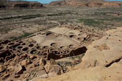 A hiker sits on a ledge above Pueblo Bonito, the largest archeological site at the Chaco Culture National Historical Park, in northwestern New Mexico, on Aug. 28, 2021.