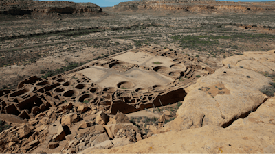 A hiker sits on a ledge above Pueblo Bonito, the largest archeological site at the Chaco Culture National Historical Park, in northwestern New Mexico, on Aug. 28, 2021.