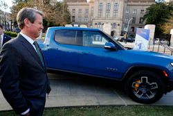 Gov. Brian Kemp smiles as he stands next to a Rivian electric truck during a ceremony to announce that the electric truck maker plans to build a $5 billion battery and assembly plant east of Atlanta projected to employ 7,500 workers, Thursday, Dec. 16, 2021, in Atlanta.