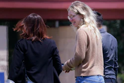 Disgraced Theranos CEO Elizabeth Holmes, center, is escorted by prison officials into a federal women's prison camp on May 30, 2023, in Bryan, Texas.