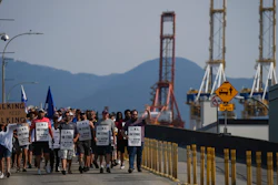 Striking workers march as gantry cranes sit idle, Vancouver, July 6, 2023.