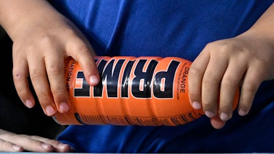 A child holds a PRIME hydration drink prior to a baseball game between the Los Angeles Dodgers and the Arizona Diamondbacks, March 31, 2023, in Los Angeles.