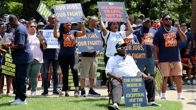 Workers hold signs supporting labor organizers at a rally in Columbia, S.C., July 12, 2023.