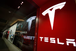 A sign bearing the Tesla company logo is displayed outside a Tesla store in Cherry Creek Mall in Denver, Feb. 9, 2019.