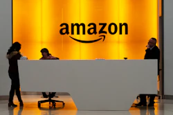 In this Feb. 14, 2019, file photo, people stand in the lobby for Amazon offices in New York.