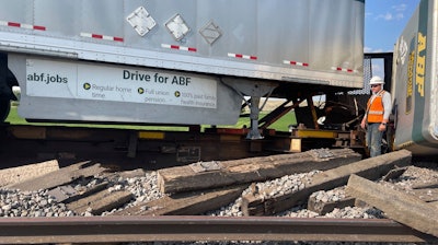 In this photo provided by Hill County Disaster and Emergency Services, a railroad worker stands among derailed freight cars from a BNSF Railway train that derailed east of Havre, Montana on Friday, July 21, 2023.