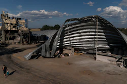 An employee walks near mangled warehouses at a grain facility in Pavlivka, Ukraine, July 22, 2023.