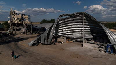 An employee walks near mangled warehouses at a grain facility in Pavlivka, Ukraine, July 22, 2023.