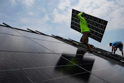 Nicholas Hartnett, owner of Pure Power Solar, carries a panel as he and Brian Hoeppner, right, install a solar array on the roof of a home in Frankfort, Ky., Monday, July 17, 2023.
