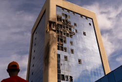 A maintenance worker outside a damaged government building in Kyiv, Aug. 2, 2023.