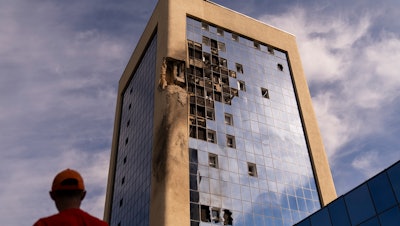 A maintenance worker outside a damaged government building in Kyiv, Aug. 2, 2023.