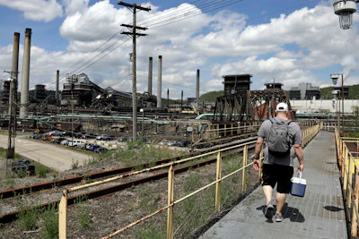 A worker arrives for a shift at the U.S. Steel Clairton Coke Works on May 2, 2019, in Clairton, Pa. With two bidders revealed in a matter of days and more in the wings, United States Steel Corp. seems poised to be purchased by a competitor sooner than later.