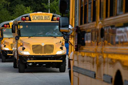 Jefferson County Public Schools buses packed with students make their way through the Detrick Bus Compound on the first day of school, Wednesday, Aug. 9, 2023, in Louisville, Ky.