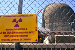 A sign warning of radioactive materials is seen on a fence around a nuclear reactor containment building, April 26, 2021, a few days before it stopped generating electricity at Indian Point Energy Center, in Buchanan, N.Y.