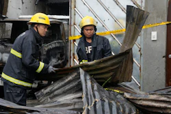 Firemen arrange steel sheets from a factory that caught fire in Quezon city, Philippines on Thursday, Aug. 31, 2023.