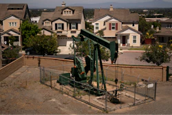 A pump jack extracts oil at a drilling site next to homes June 9, 2021, in Signal Hill, Calif.