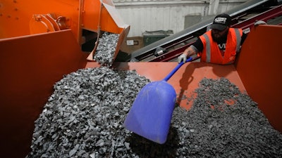 K.C. Skillern moves material with a shovel from recycled solar panels at We Recycle Solar on Tuesday, June 6, 2023, in Yuma, Ariz.