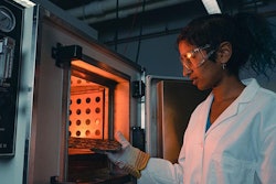 Purdue student Anna Murray places printed circuit board samples into an oven to test for stability and other important qualities in electronic components.