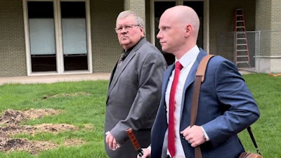 The former head of a Michigan marijuana licensing board Rick Johnson, left, walks with his attorney Nick Dondzila, outside federal court, Tuesday, April 25, 2023, in Grand Rapids, Mich.