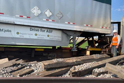A worker stands among derailed freight cars near Havre, Montana, July 21, 2023.