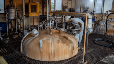A technician looks through a lid into a culture vessel for yeast development at Bajaj Hindustan Sugar factory that produces ethanol, a type of biofuel, in Meerut, India, Wednesday, Aug. 23, 2023.