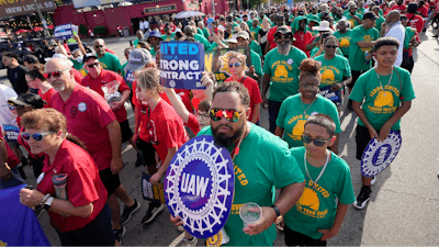 United Auto Workers members walk in the Labor Day parade in Detroit, Monday, Sept. 4, 2023.