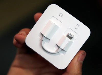 A customer holds a Lightning to 3.5mm headphone jack adapter cable at the Apple Store on Michigan Avenue, Friday, Sept. 16, 2016, in Chicago.
