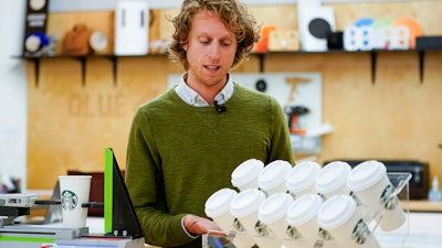 Senior packaging engineer Kyle Walker explains a tilt test for cups at the Tryer Center at Starbucks headquarters, Seattle, June 28, 2023.