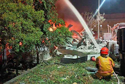 In this image provided by the Pingtung County Government, a firefighter tries to extinguish a fire at a factory of golf ball manufacturer Launch Technologies Co. in the southern county of Pingtung in Taiwan on Friday, Sept. 22, 2023.
