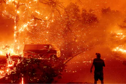 Bruce McDougal watches embers fly over his property as the Bond Fire burns through the Silverado community in Orange County, Calif., Dec. 3, 2020.