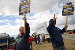 Striking United Auto Workers members Rob Marchese, left, and Neil Peters picket at the Stellantis Toledo Assembly Complex on Oct. 7, 2023, in Toledo, Ohio.