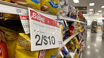 A sale sign hangs below a shelf of potato chips in a Target store in Sheridan, Colo., Oct. 4, 2023.