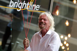 Richard Branson, of Virgin Group, prepares to unfurl a banner during a naming ceremony for the Brightline train station, to be renamed as Virgin MiamiCentral in Miami on April 4, 2019.