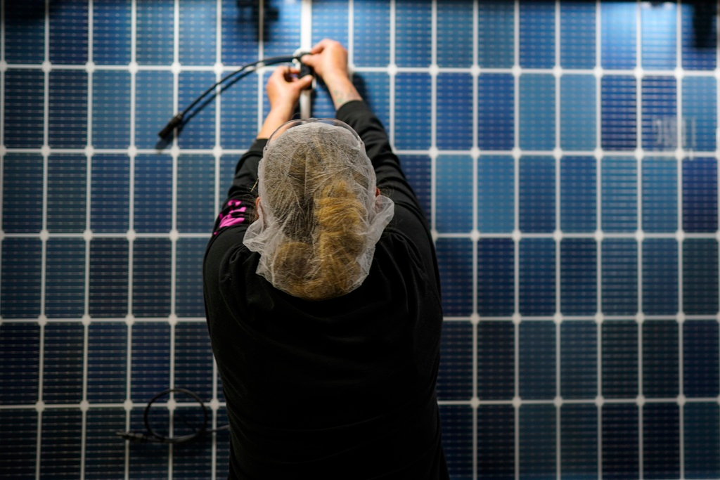 An employee works on a solar panel inside the Hanwha Qcells Solar plant, Monday, Oct. 16, 2023, in Dalton, Ga.