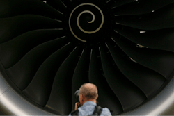 A visitor takes a photo of the Rolls-Royce jet engine of the Airbus A350-1000 parked at the static display area during the Singapore Airshow on Feb. 7, 2018, in Singapore.