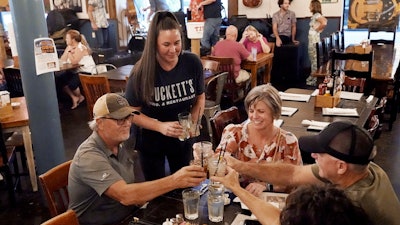Macy Norman, center, serves a table of guests at Puckett's Grocery and Restaurant, Nashville, Sept. 10, 2021.