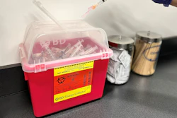 A BD Sharps Collector full of used syringes.