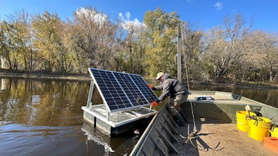 Minnesota DNR Fisheries Technician James Stone works to remove a floating telemetry receiver from the Mississippi River backwaters near La Crosse, Wis., Nov. 6, 2023.