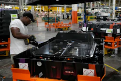 An assembly line worker uncrates an LG battery at the General Motors Orion Assembly, Thursday, June 15, 2023, in Lake Orion, Mich. On Friday, the U.S. government issues the October jobs report.