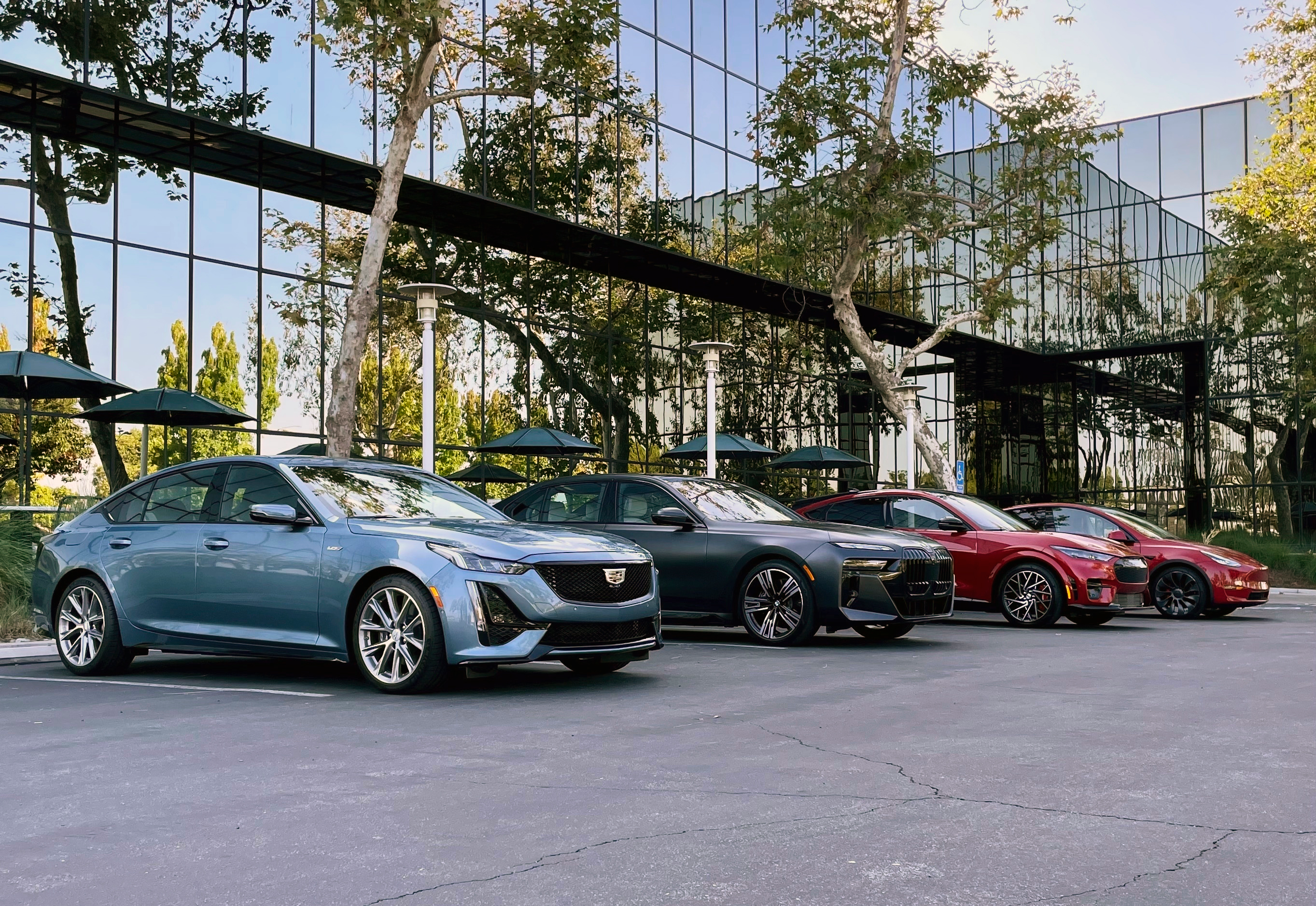 This photo provided by Edmunds shows the BMW i7, Cadillac CT5-V, Ford Mustang Mach-E and Tesla Model Y.
