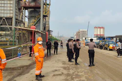 Police officers and workers stand near the site where a furnace explosion occurred at PT Indonesia Tsingshan Stainless Steel smelting plant in Morowali, Central Sulawesi, Indonesia, Sunday, Dec. 24, 2023.